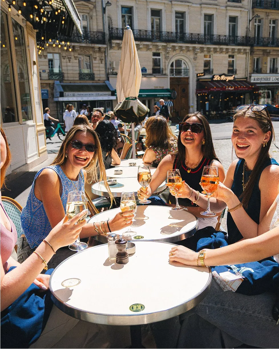 Groupe d’amis partageant des boissons en terrasse au restaurant Tivoli
